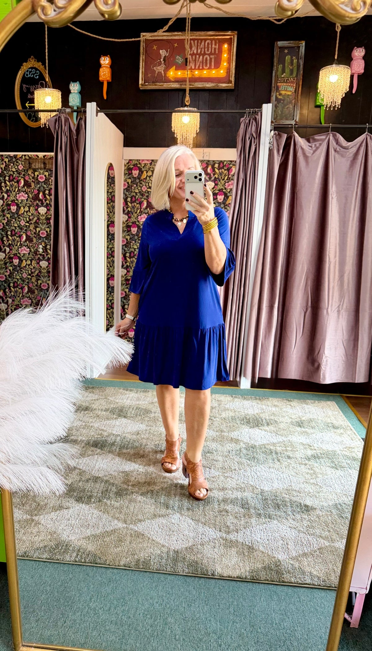 Navy blue relaxed fit dress with three-quarter sleeves, tiered design, and shirring details, styled with accessories.