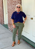 Olive green jogger with elastic waist and tapered legs, styled with a navy top and brown accessories outdoors.
