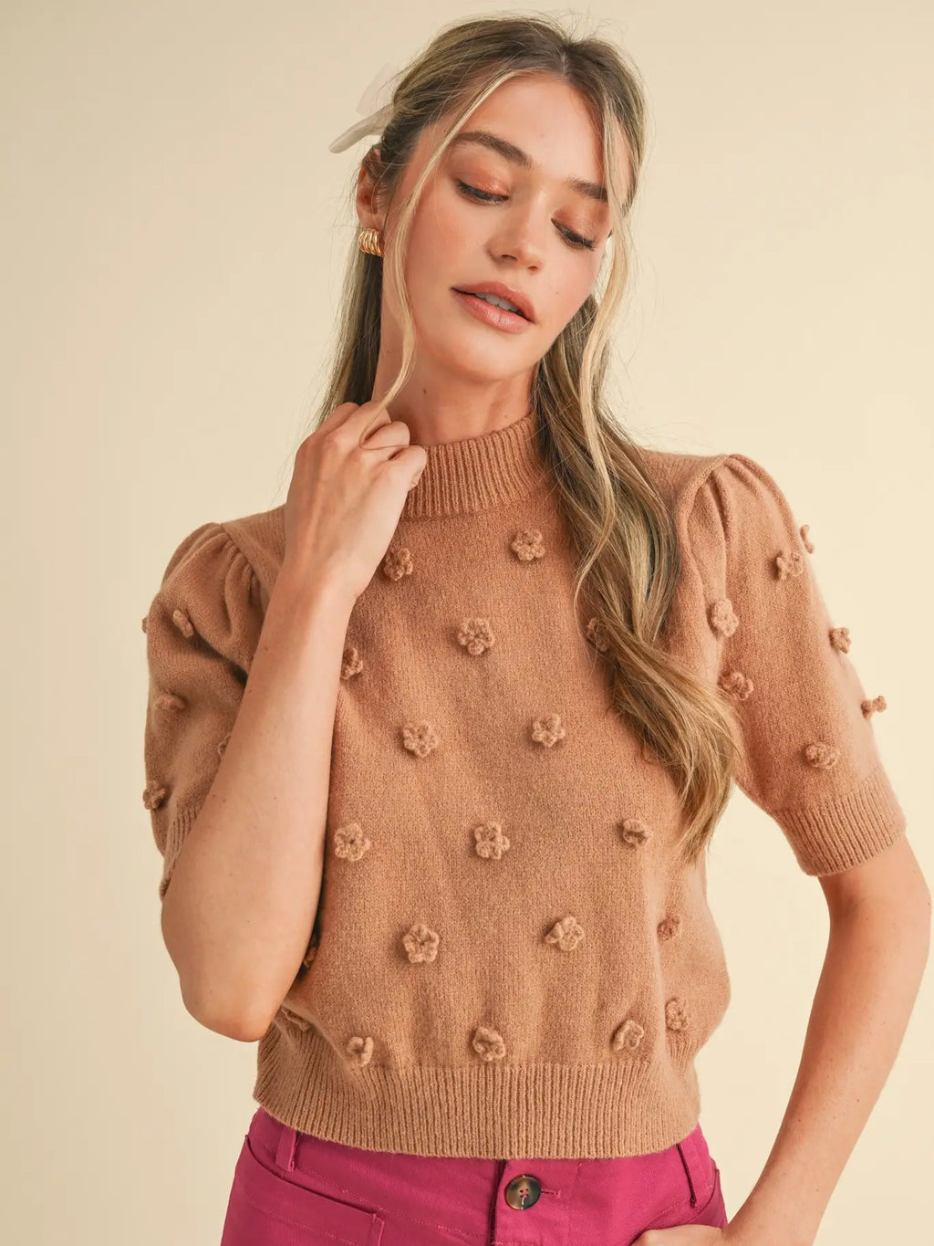 Taupe 3D floral knit short sleeve sweater with mock ribbed neckline and short puff sleeves styled with pink pants.