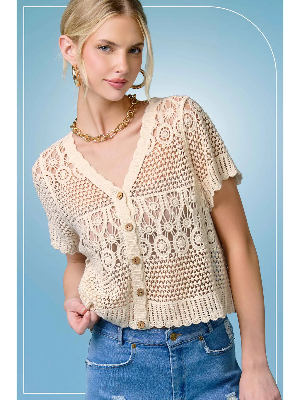 Open-knit cardigan with scalloped edges, V-neck, and button-down front, styled over a casual outfit.