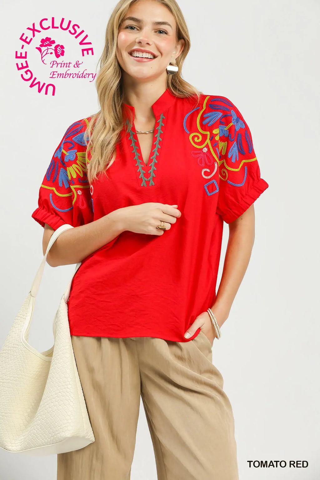 Vibrant tomato red blouse with split V-neck, short puff sleeves, and multicolor embroidery, styled with loose-fitting pants.