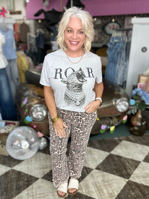 Woman wearing a light gray Cheetah Roar Graphic T-Shirt with rhinestones, featuring a bold 'ROAR' design.