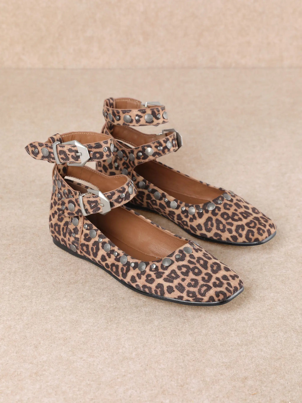 Leopard print flats with square toe, ankle straps, silver-toned grommets, and side buckle fastening.
