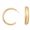 Gold hammered hoop earrings with a shiny finish, showcasing a circular shape and textured detailing.