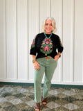 Olive straight jeans styled with a black embroidered top and brown heeled shoes, featuring a high-rise design.