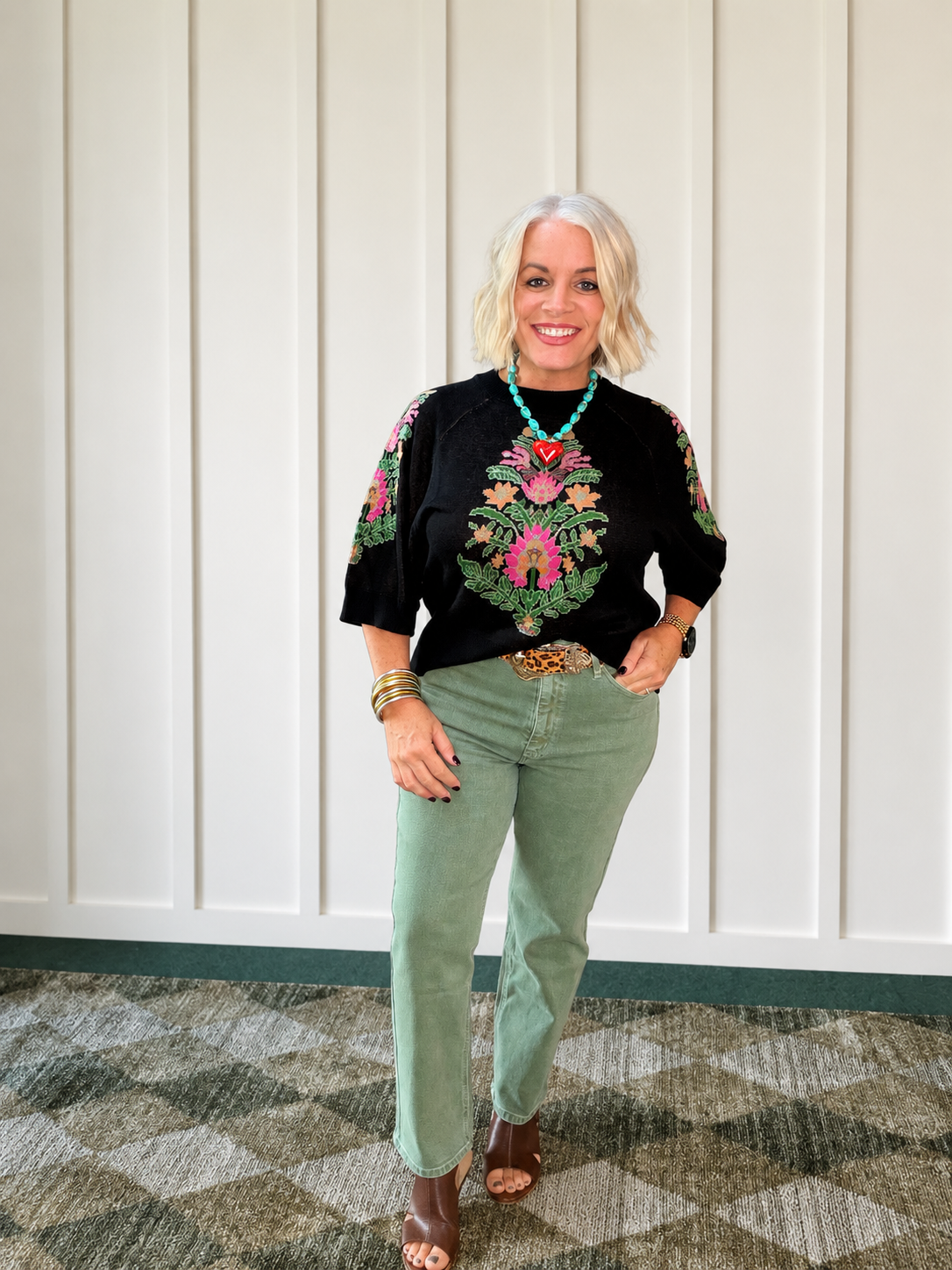 Olive straight jeans styled with a black embroidered top and brown heeled shoes, featuring a high-rise design.
