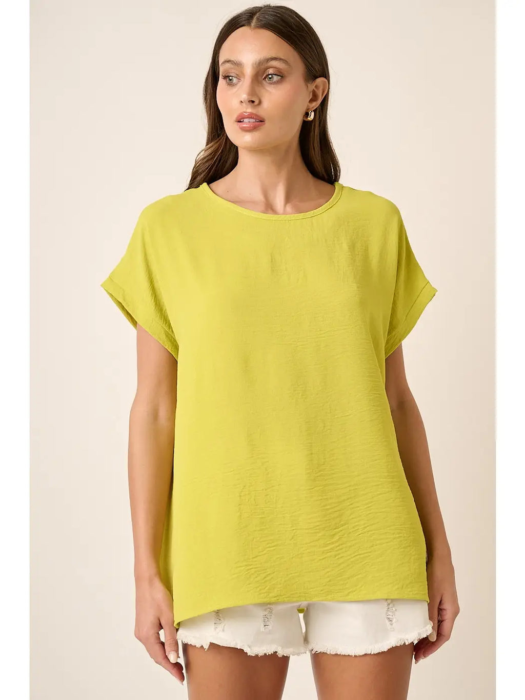 Bright lime oversized dolman top with short sleeves and round neckline, styled with white shorts.