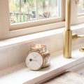 Mercury jar candle emitting a warm glow on a windowsill, featuring the Sweet Grace fragrance.