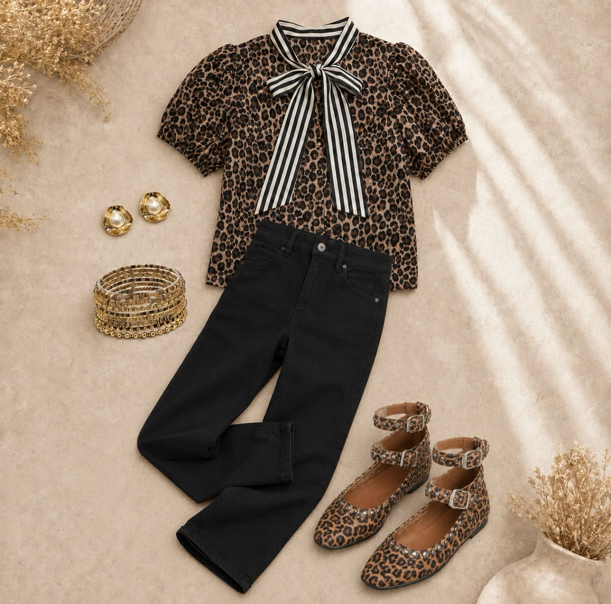 Leopard print blouse with striped scarf neck, short sleeves, styled with black jeans and matching leopard print shoes.