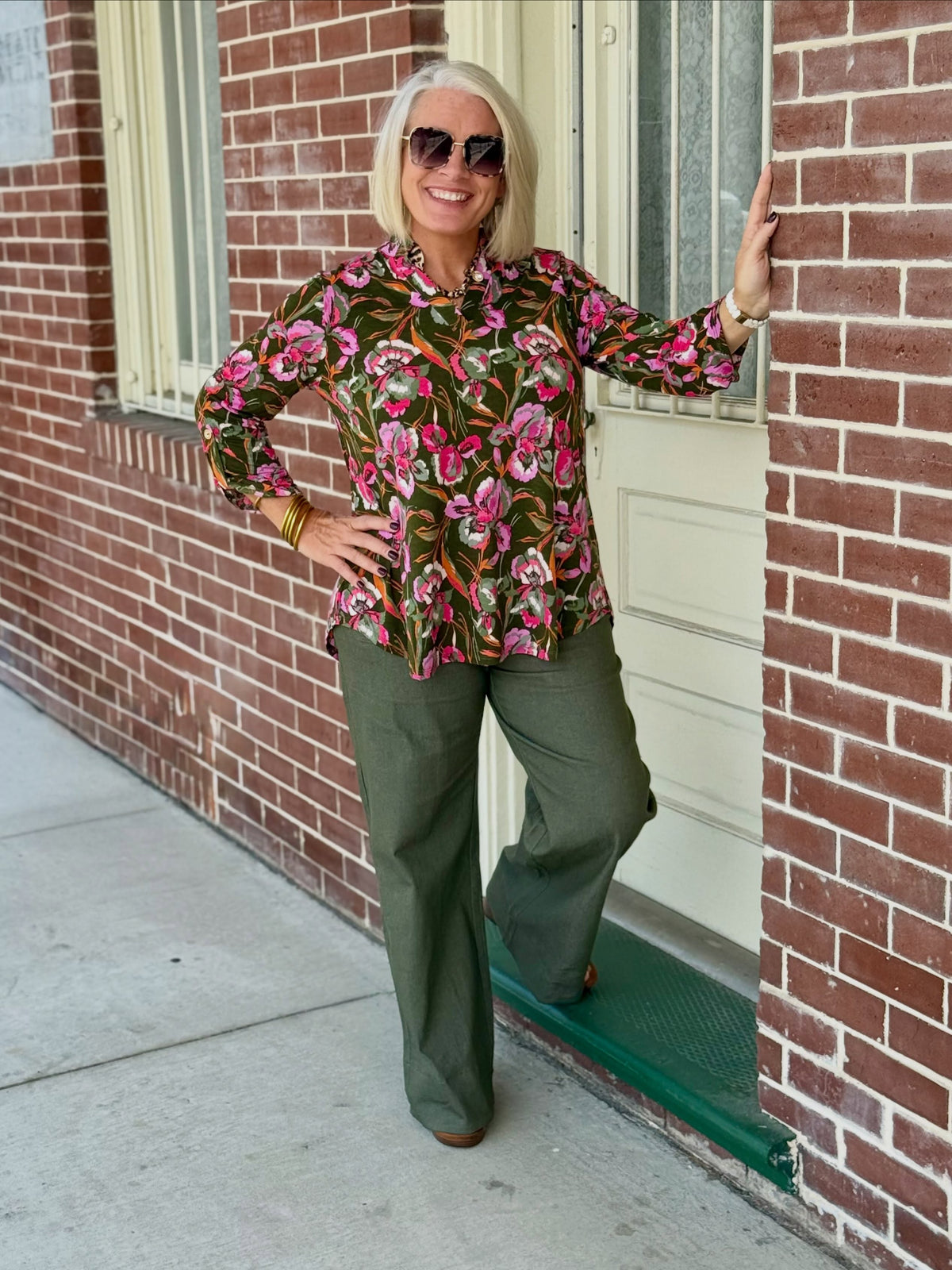 Olive high-rise wide-leg pants with front pockets, styled with a floral top in an outdoor setting.